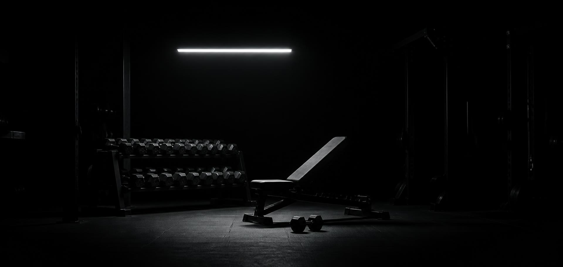 Dark gym at night lit by a single GYMLIGHT light bar